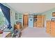 Cozy bedroom featuring pale blue walls, neutral carpet, hardwood furniture, and a large window at 225 Berthoud Way, Golden, CO 80401