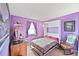 Purple bedroom featuring carpet, hardwood floors, Murphy bed, and a window at 225 Berthoud Way, Golden, CO 80401