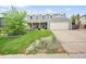 Inviting two-story home showcasing a well-manicured lawn, mature trees, and a spacious driveway leading to a garage at 225 Berthoud Way, Golden, CO 80401