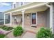 Welcoming front porch featuring brick accents, comfortable seating, and a charming entrance to the home at 225 Berthoud Way, Golden, CO 80401