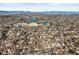 An aerial view features a well-distributed residential area with neighborhood lakes and the mountains in the distance at 2237 S Lowell Blvd, Denver, CO 80219