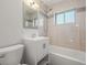 Clean bathroom featuring modern fixtures, a shower-tub combo, and tiled walls at 2237 S Lowell Blvd, Denver, CO 80219