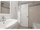 Bathroom featuring a tiled shower, a white sink, and a doorway leading to another room at 2237 S Lowell Blvd, Denver, CO 80219