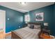 Serene bedroom with blue walls and warm wood floors offering a cozy retreat at 2237 S Lowell Blvd, Denver, CO 80219