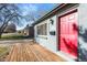 Cozy home exterior showcasing a vibrant red door, a wooden porch, and neat landscaping at 2237 S Lowell Blvd, Denver, CO 80219