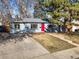 Charming single-story home featuring a red front door, a well-maintained lawn, and a mature tree at 2237 S Lowell Blvd, Denver, CO 80219