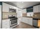 Well-equipped kitchen with stainless steel appliances, ample white cabinetry, and unique backsplash at 2237 S Lowell Blvd, Denver, CO 80219