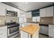 Bright kitchen with stainless steel appliances, white cabinets, and unique backsplash design at 2237 S Lowell Blvd, Denver, CO 80219