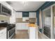 Modern kitchen featuring stainless steel appliances, white cabinetry, stylish backsplash and an adjacent island at 2237 S Lowell Blvd, Denver, CO 80219