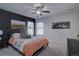 Cozy bedroom featuring a ceiling fan, black accent wall, and bright windows for natural light at 5936 Turnstone Pl, Castle Rock, CO 80104