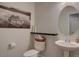 Neat half bath with a pedestal sink and attractive wall art at 5936 Turnstone Pl, Castle Rock, CO 80104