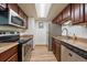 The kitchen features stainless steel appliances, brown cabinetry and wood-look flooring at 8555 Fairmount Dr # A108, Denver, CO 80247