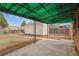 Backyard patio with a metal awning highlights an outdoor shed with a wooden fence, perfect for storage and relaxation at 3550 Fairfax St, Denver, CO 80207