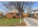 A cozy, one-story brick home featuring a well-manicured lawn and appealing curb appeal at 3550 Fairfax St, Denver, CO 80207