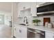 Bright kitchen features white cabinets, stainless steel appliances, quartz counters, and a stylish black faucet at 3550 Fairfax St, Denver, CO 80207