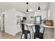 Well-lit kitchen with stainless steel appliances, white cabinetry, a breakfast bar, and stylish modern fixtures at 3550 Fairfax St, Denver, CO 80207