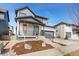 Modern two-story home featuring gray and white siding, a covered porch, and a two-car attached garage at 5604 Grandville Ave, Longmont, CO 80503