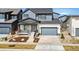 Charming home with gray and white siding, a covered porch, an attached two-car garage, and landscaped front yard at 5604 Grandville Ave, Longmont, CO 80503