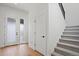 Bright foyer featuring hardwood floors, a staircase with gray carpet, and a modern glass paneled front door at 5604 Grandville Ave, Longmont, CO 80503