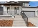 Close-up of the front entrance featuring a modern door, landscaping, and stairs leading to the covered porch at 5604 Grandville Ave, Longmont, CO 80503
