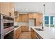Modern kitchen with stainless steel appliances, light wood cabinets, white countertops and stylish backsplash at 5604 Grandville Ave, Longmont, CO 80503