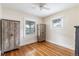 Bedroom featuring neutral walls, hardwood floors, two windows and two decorative wooden cabinets at 2074 S Emerson St, Denver, CO 80210