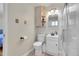 Cozy bathroom featuring a shower, toilet, vanity, and tiled floor, illuminated by decorative lighting fixtures at 3175 W Stanford Ave, Englewood, CO 80110