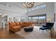 Bright living room with a leather sectional sofa and large windows showcasing scenic views at 9524 Fork Bluff Pt, Lone Tree, CO 80124
