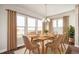 Dining room featuring neutral decor, a wooden table for six, large windows, and modern chandelier at 21295 E 61St Dr, Aurora, CO 80019