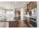 Spacious kitchen features stainless steel appliances, a center island and modern lighting at 21295 E 61St Dr, Aurora, CO 80019