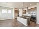 Open kitchen features wood floors, central island, stainless appliances and modern pendant lighting at 21295 E 61St Dr, Aurora, CO 80019