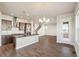 Gourmet kitchen with stainless appliances, island seating, wood floors, and an open staircase at 21295 E 61St Dr, Aurora, CO 80019