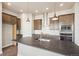 Kitchen featuring stainless steel appliances, center island with sink, and wood floors at 21295 E 61St Dr, Aurora, CO 80019