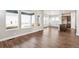 Sun-filled room boasts wood floors and is adjacent to a kitchen island with pendant lighting at 21295 E 61St Dr, Aurora, CO 80019
