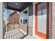 Inviting porch with brick accents, a modern railing, and a bright orange front door at 21295 E 61St Dr, Aurora, CO 80019