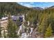 Overhead view of a grey mountain home surrounded by lush forest and mountain views at 379 Rainbow Rd, Idaho Springs, CO 80452