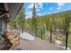Spacious wooden deck features mountain views, wood chairs, and snowy areas at 379 Rainbow Rd, Idaho Springs, CO 80452