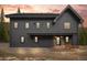 Charming two-story grey home with a woodpile near the entrance and beautiful twilight sky at 379 Rainbow Rd, Idaho Springs, CO 80452