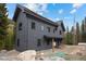 Two-story grey mountain home highlighting the landscaping and proximity to the forest at 379 Rainbow Rd, Idaho Springs, CO 80452
