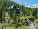 Secluded mountain home surrounded by a forest with a creek in the foreground at 379 Rainbow Rd, Idaho Springs, CO 80452