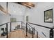 Hallway with hardwood floors, cable railing, wooden beams, and staircase to living area at 379 Rainbow Rd, Idaho Springs, CO 80452