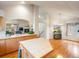 Bright kitchen with wood floors, a kitchen island, and an open layout connected to the living spaces at 7158 W Belmont Dr, Littleton, CO 80123
