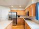 Modern kitchen with stainless steel appliances, tile countertops, wood floors, and wood cabinets at 7158 W Belmont Dr, Littleton, CO 80123