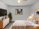 Cozy bedroom with modern decor, including stylish dresser, plant, and sleek TV setup at 1394 E Panama Dr, Centennial, CO 80121