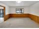 Bright living room with wood paneling, neutral carpet, and a view to the outside at 1394 E Panama Dr, Centennial, CO 80121