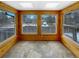Bright sunroom with multiple windows, natural stone floor, and wood paneled walls at 1394 E Panama Dr, Centennial, CO 80121