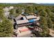 Aerial view of a multi-story home with a bocce ball court, covered porch, and surrounding mature trees at 2851 Interlocken Dr, Evergreen, CO 80439