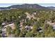 Scenic aerial view of a home surrounded by dense trees and snow-dusted landscape with mountain view in the background at 2851 Interlocken Dr, Evergreen, CO 80439