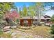 Lush backyard featuring a pond, gazebo, mature trees, and extensive rock landscaping at 2851 Interlocken Dr, Evergreen, CO 80439