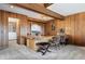 Custom wood wet bar with seating, unique lighting, adjacent bonus area, and carpeted flooring at 2851 Interlocken Dr, Evergreen, CO 80439